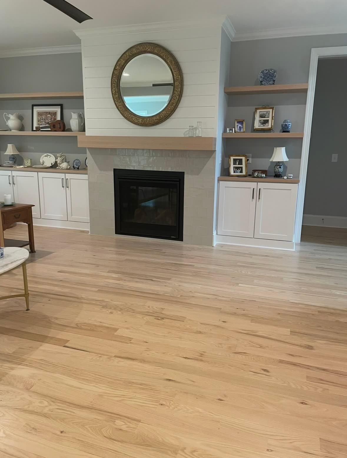 Wide-plank white oak hardwood floor in a great room with built-in cabinetry and a tile fireplace