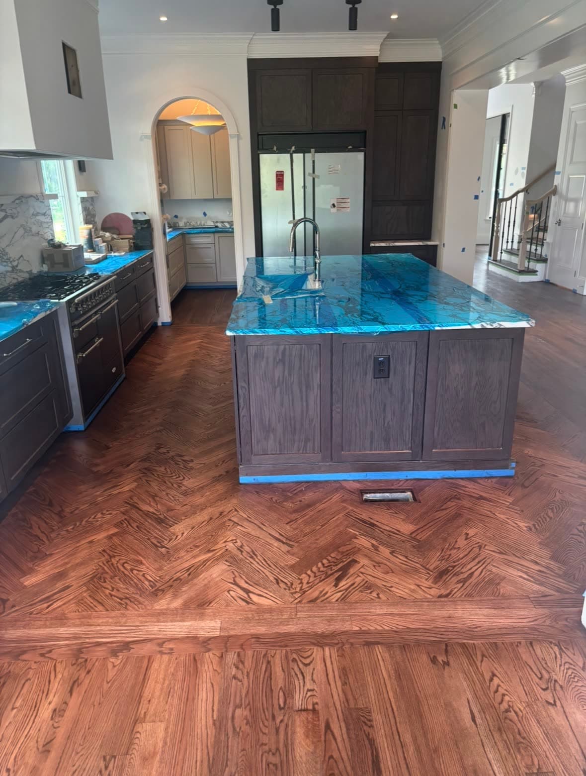Custom kitchen with herringbone red oak hardwood floor and a blue agate island — a recent Gladden project